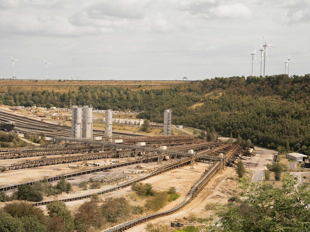 Industrial site with wind turbines on the horizon